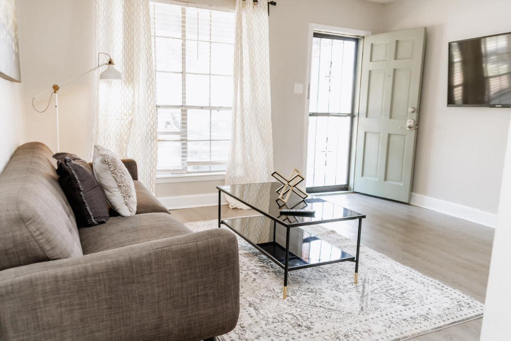 ein Wohnzimmer mit Sofa und einem Couchtisch aus Glas in der Unterkunft Parkside & Broadview Memphis Comfort in City Ctr in Memphis