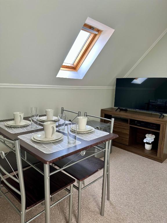 a dining room with a table and a television at Latitud Stays Puerto Montt in Puerto Montt