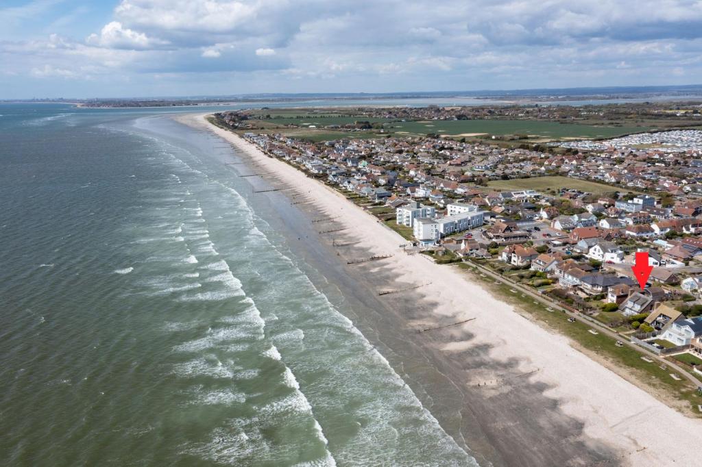 eine Luftansicht auf einen Strand mit Häusern in der Unterkunft Tamarisk Cottage, East Wittering in East Wittering