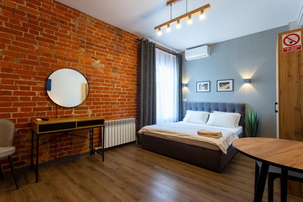 une chambre avec un lit et un mur de briques dans l'établissement Затишна квартира в центрі на Харківській набережній 3-3, à Kharkov