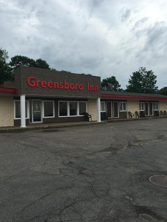 a gas station with a greenzone inn on the street at The Greensboro Inn in New Minas