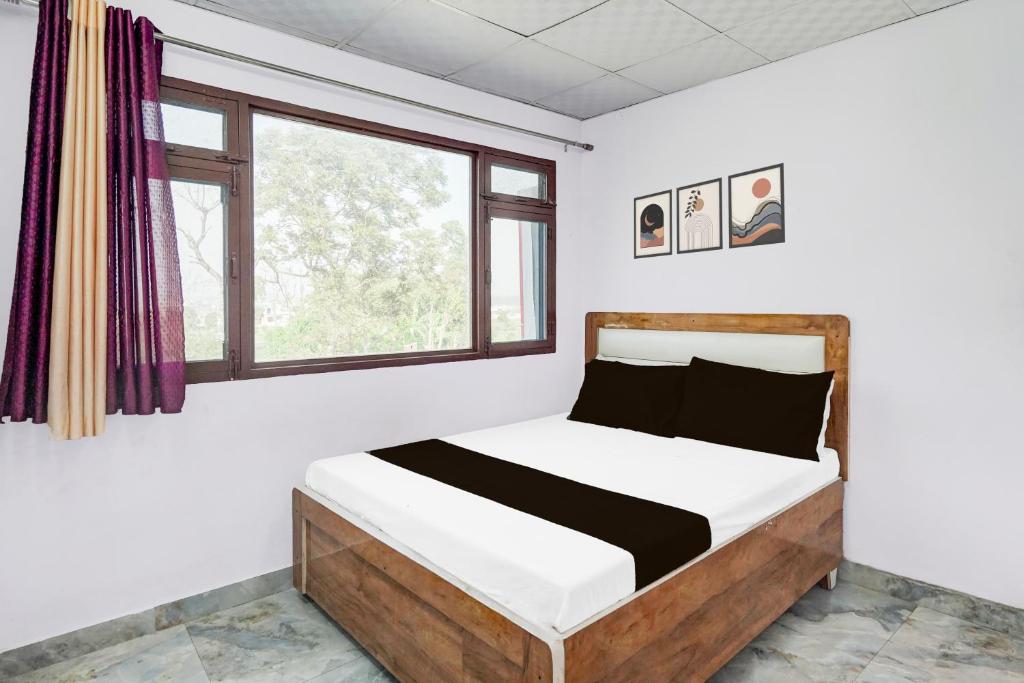 una cama en una habitación con ventana en Hotel O Riyansh Restaurant and hotel, en Jhājra