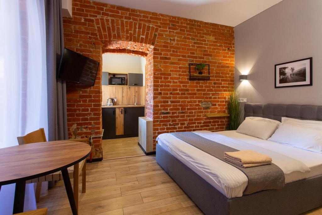 a bedroom with a bed and a brick wall at Нова квартира в центрі на Харківській набережній 3-4 in Kharkiv