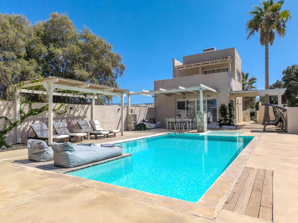 a swimming pool in front of a house at Almirikia in Pigianos Kampos