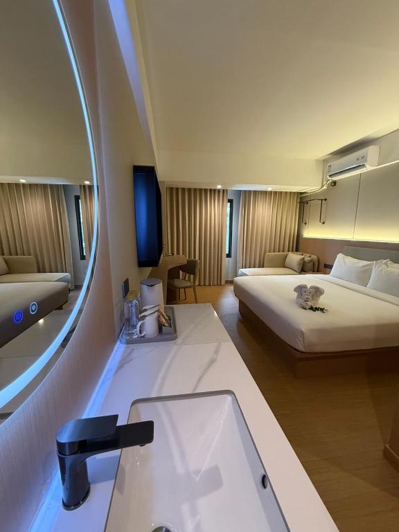 a hotel room with a bed and a sink and a mirror at Star Hotel Pattaya in Pattaya