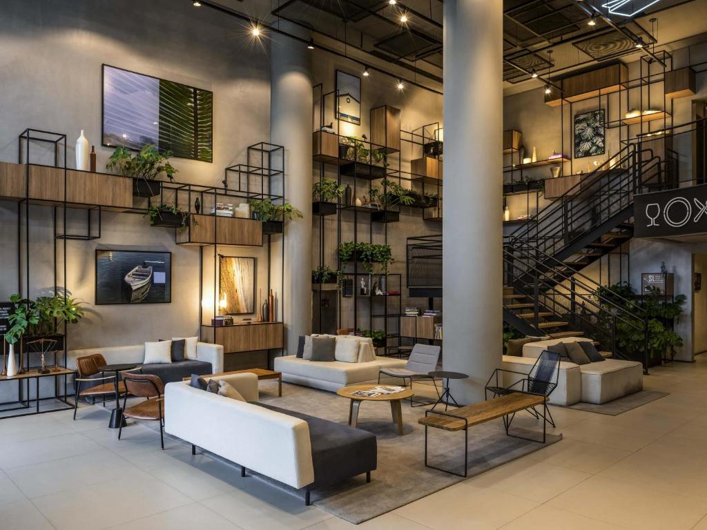 a lobby with couches and chairs and a staircase at ibis Sao Paulo Barra Funda in Sao Paulo