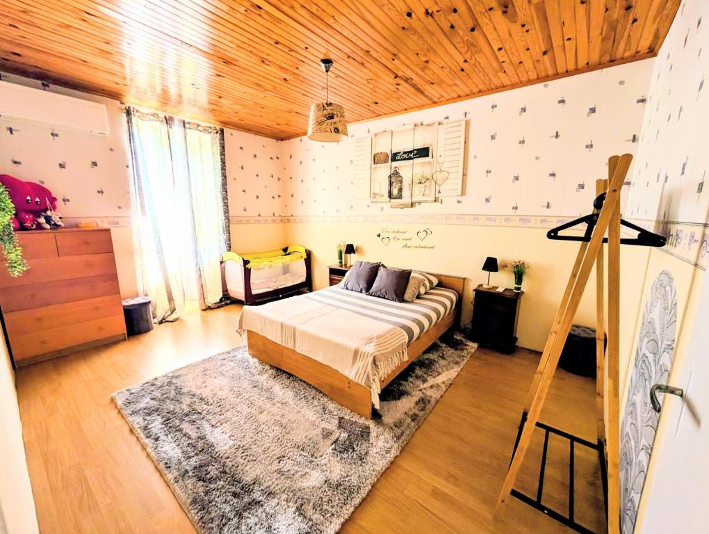 a bedroom with a bed and a wooden ceiling at L'échappée Huroise, piscine et spa privatifs in Hure