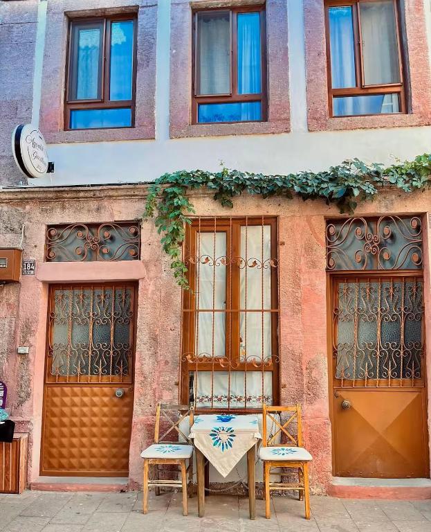 a table and two chairs in front of a building at Ayvalık Sezer Konukevi in Ayvalık