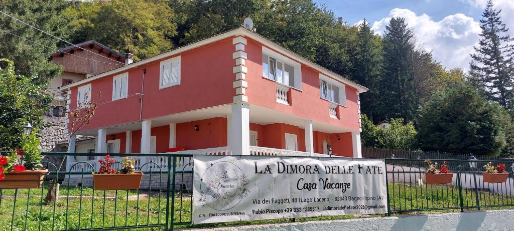 a red house with a sign in front of it at Casa Greta La Dimora delle Fate in Villaggio Laceno