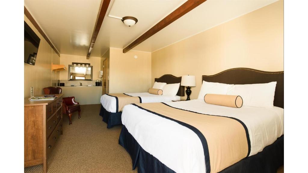 ein Hotelzimmer mit zwei Betten und einem Schreibtisch in der Unterkunft St James A2 in Cimarron