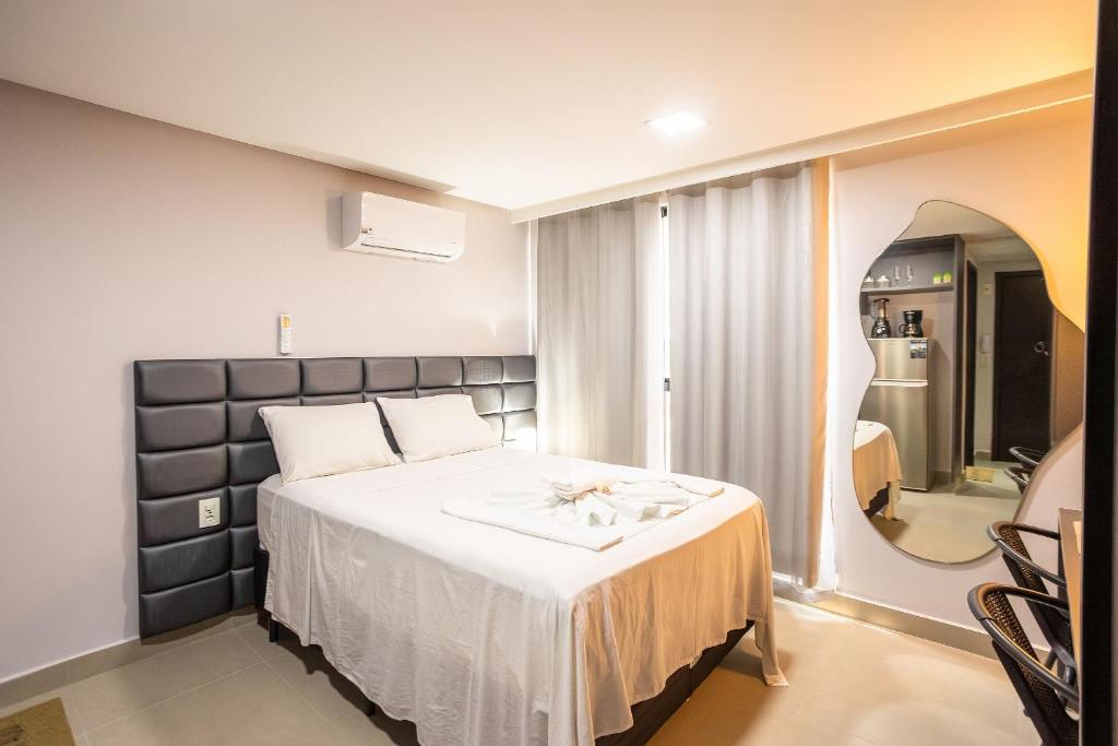 a bedroom with a large bed and a mirror at Way Tambaú #C4 - Duplo deluxe by Carpediem in Tambaú