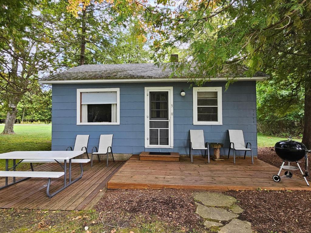 ein blaues Haus mit Stühlen und einem Grill auf einer Terrasse in der Unterkunft Brookhaven 3 in Maple City