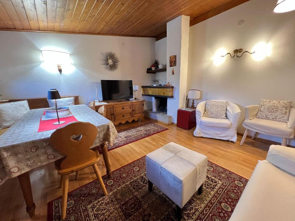 a living room with a table and a couch and a tv at Apartment 5 Torri, parcheggio in garage in Cortina dʼAmpezzo