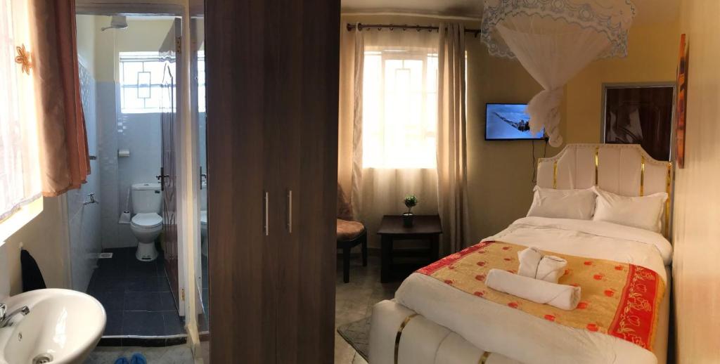 a bedroom with a large bed and a bathroom at Atlantis City BnB in Nakuru
