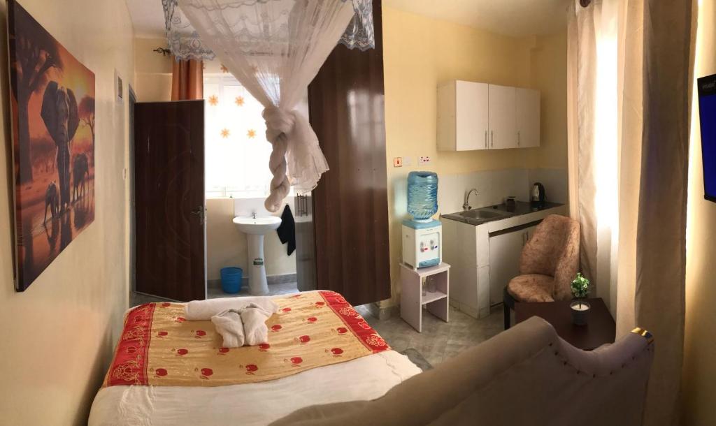 een slaapkamer met een bed en een keuken bij Atlantis City BnB in Nakuru