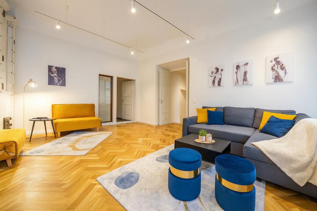 a living room with a blue couch and yellow chairs at 74m2 Newly renovated lux furnished Old town in Tallinn