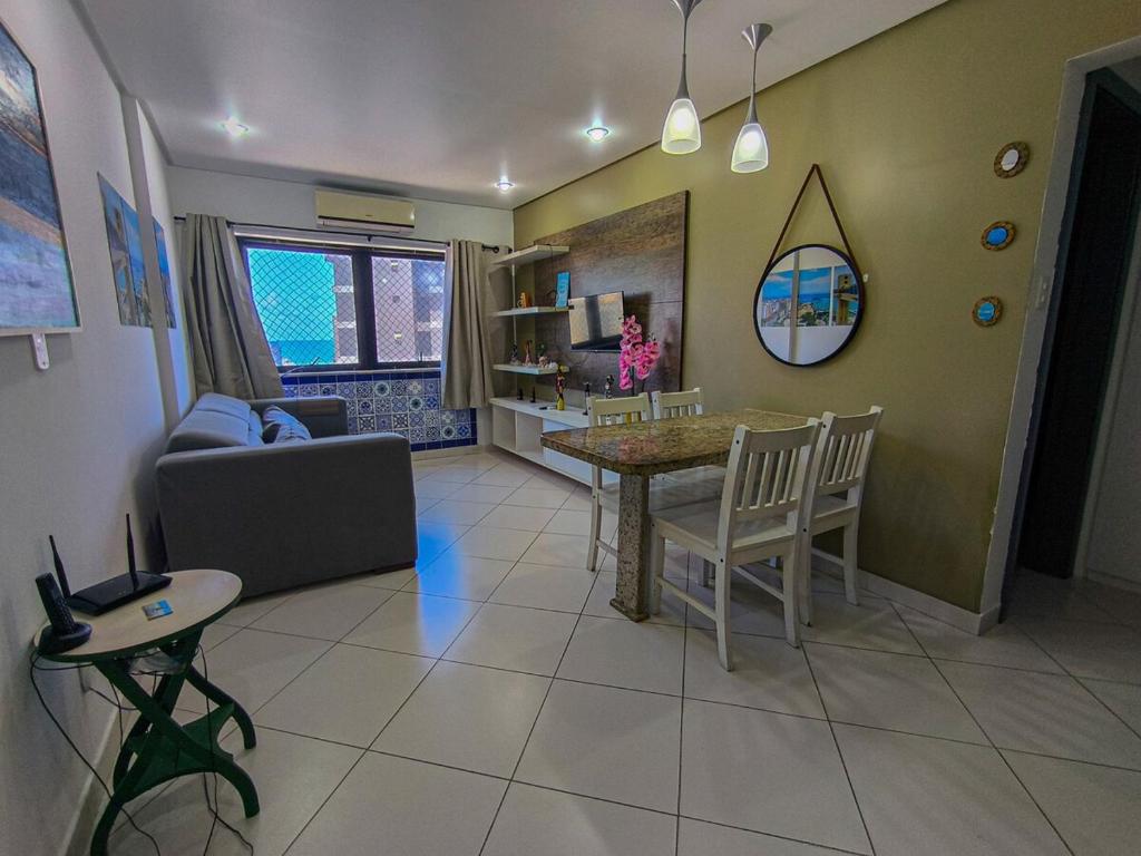 a living room with a table and a couch at Quarto e Sala completo com Cozinha, Ar condicionado, Wifi e Camareira in Salvador