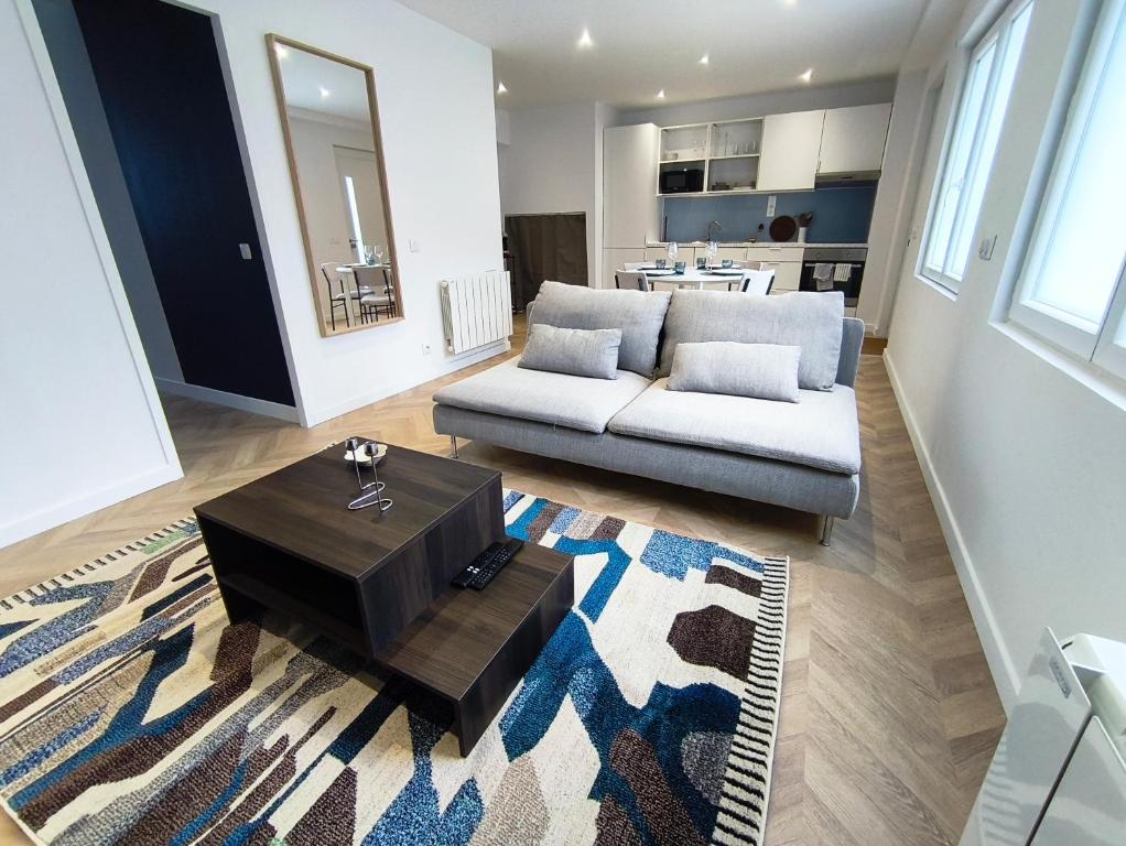 a living room with a couch and a coffee table at L'Azur - Appartement spacieux - Arrivée Autonome in Brest
