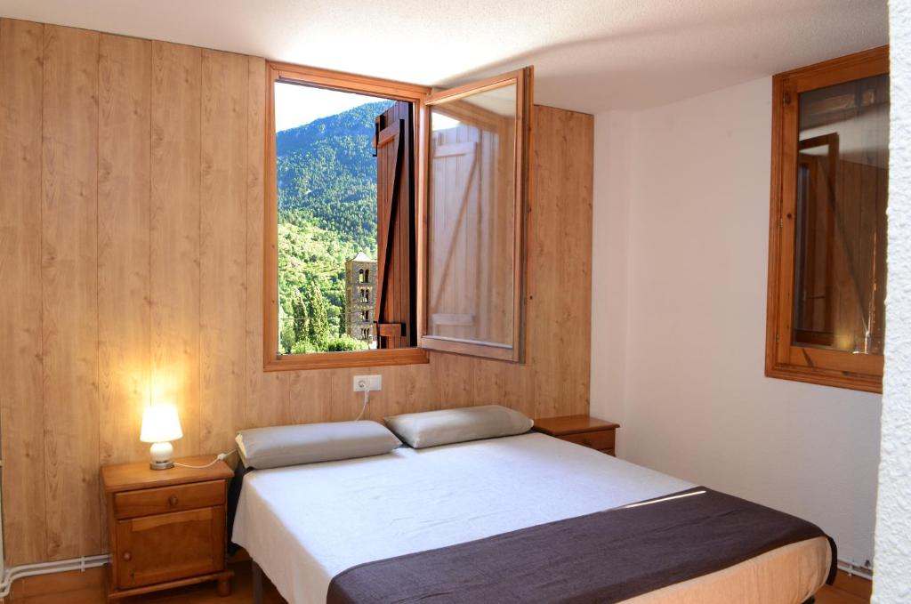 a bedroom with a bed and a large window at Habitacions La Coma de Taüll in Taull