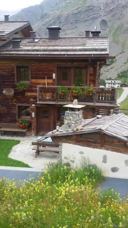 a log house with a porch and a fountain in front of it at Chalet Pila in Livigno