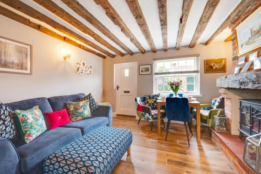 ein Wohnzimmer mit Sofa und Tisch in der Unterkunft Puddingmoor Cottage in Beccles
