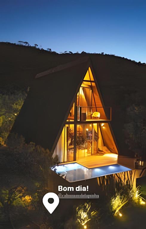 a frame house with a black roof at night at Cabana Zé da Lapinha - Passarela in Santana do Riacho