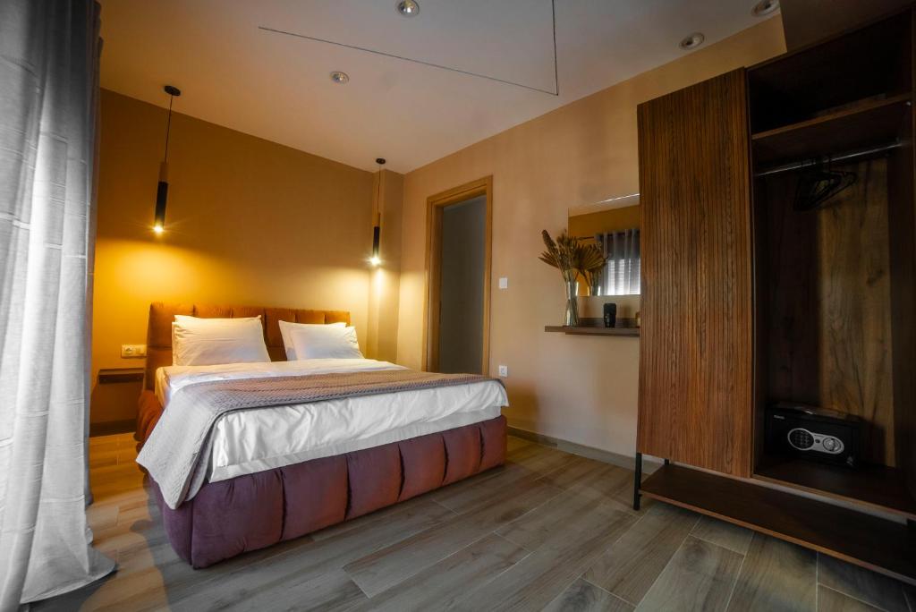 een slaapkamer met een groot bed en een televisie bij Coloris Rubrum room in Thessaloniki