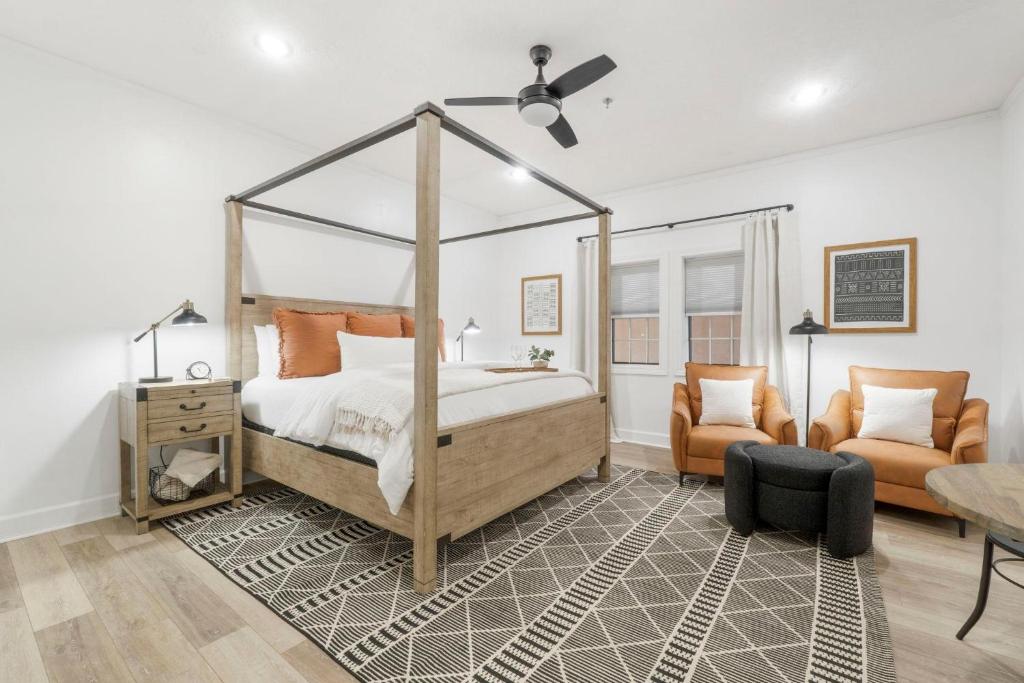 Un dormitorio con una cama con dosel y una silla. en Village of SoWal B257, en Rosemary Beach