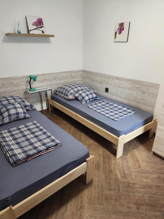 - 2 lits dans une chambre dotée de parquet dans l'établissement Friendly Guesthouse Kecskemét, à Kecskemét