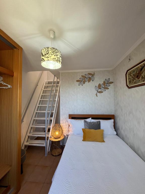 a bedroom with a bed and a stair case at Tropical House in Ribeira Brava