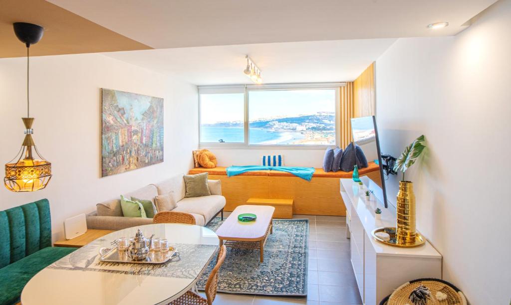 una sala de estar con un sofá y una mesa en Elegant Hilton Penthouse, en Charf