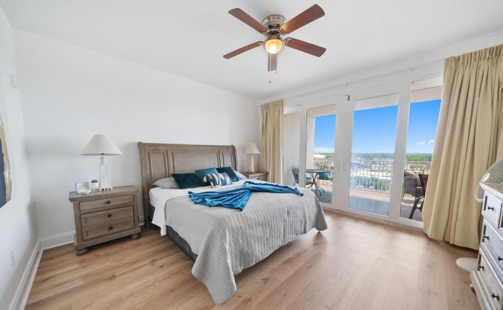 een slaapkamer met een bed en een plafondventilator bij Laketown Wharf 1134 in Panama City Beach