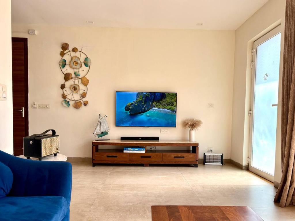 un soggiorno con una TV a schermo piatto su una parete di The Greendoor Villa - Veera Casa, pool, near beach ad Assagao