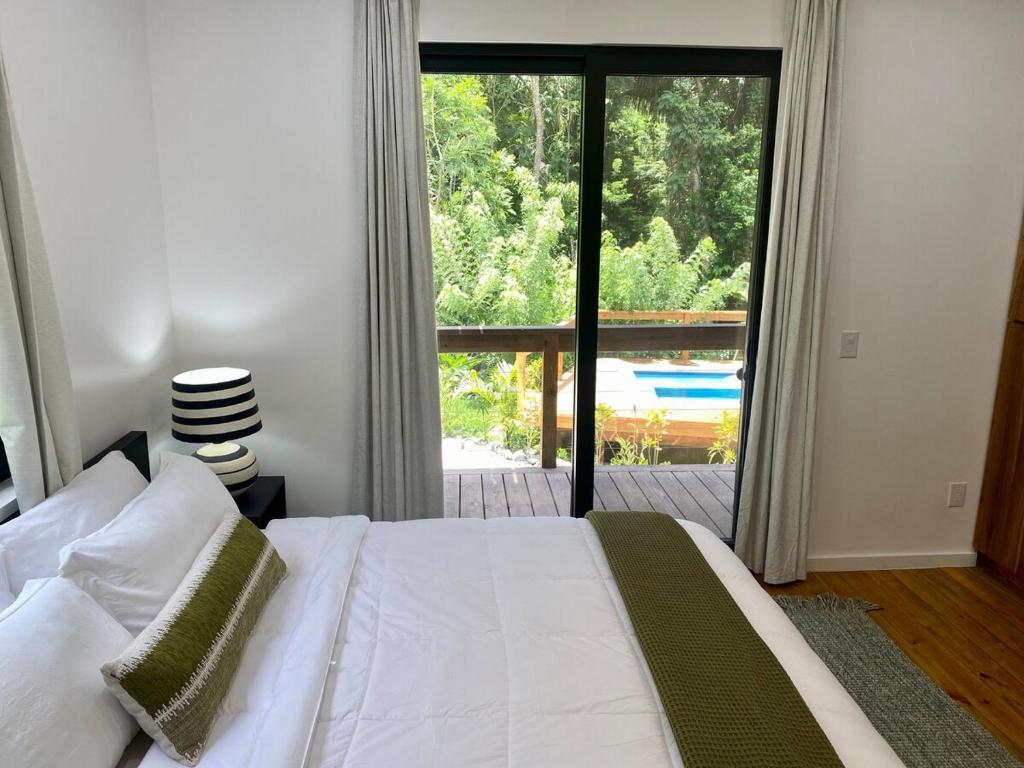 a bedroom with a bed and a large window at Villa Cass in West End