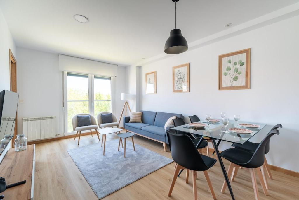 a living room with a blue couch and a table at Baiona by Ladeira in Baiona