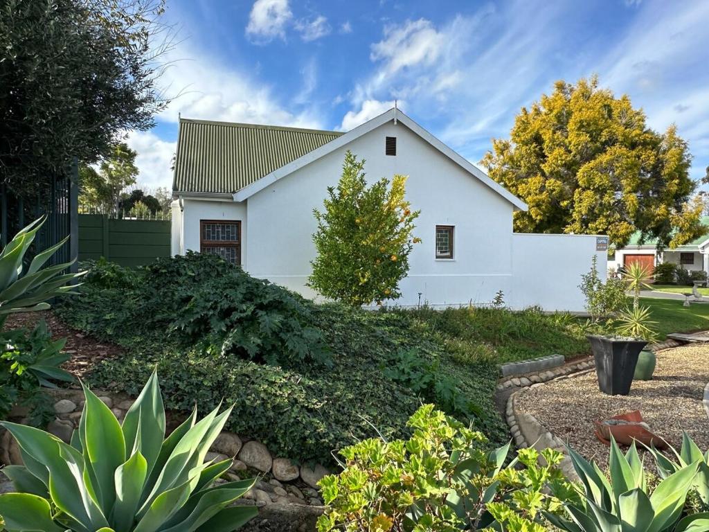 Maison blanche avec aménagement paysager dans l'établissement Rose Garden, a Self-catering cottage, à Worcester
