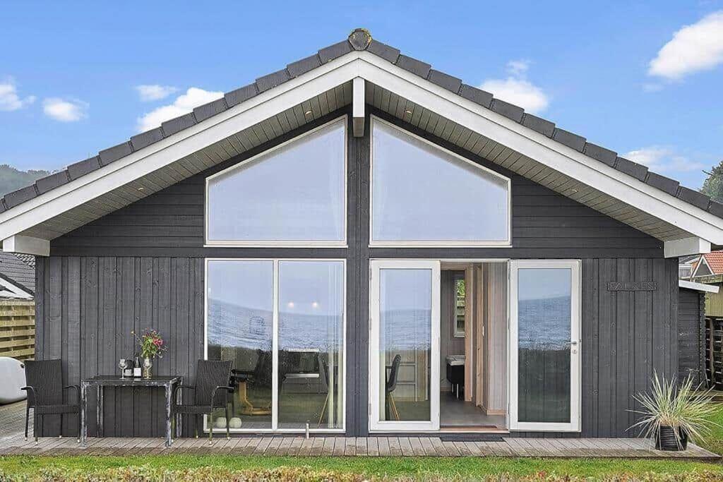 a house with large windows and a table and chairs at SJ308-Sjolund-Gl-Strandvej-29 in Binderup Strand