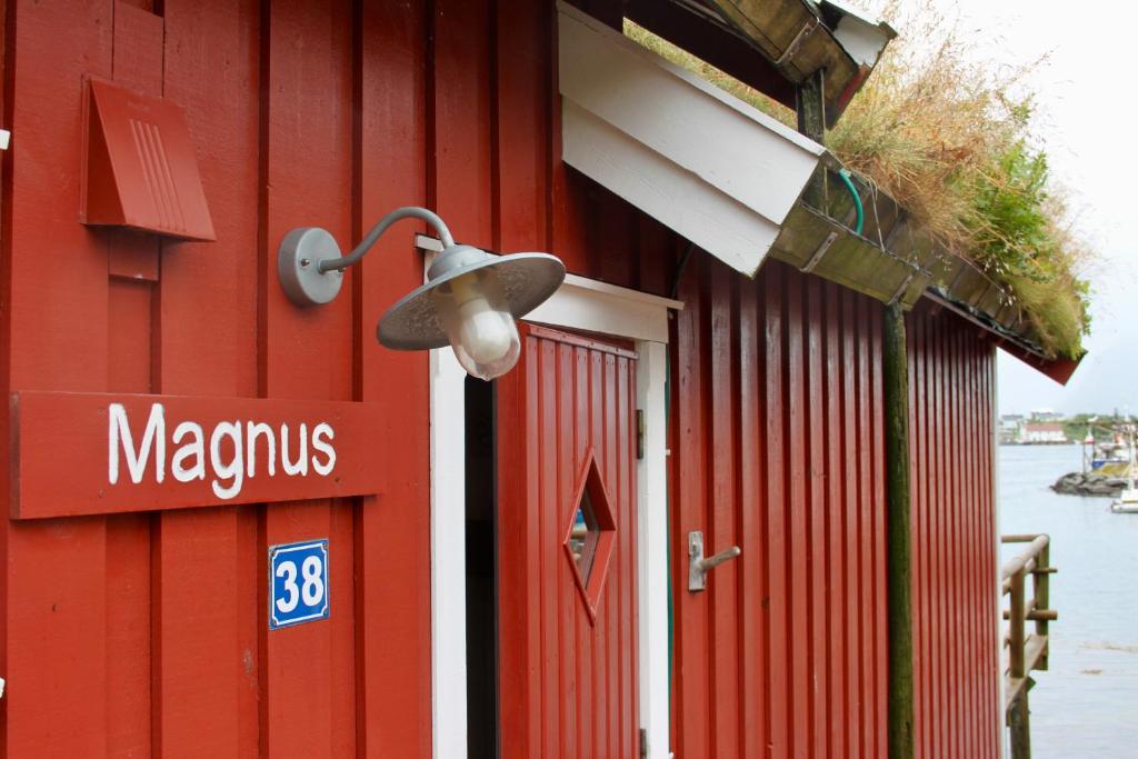 un bâtiment rouge avec une lumière sur son côté dans l'établissement Magnusbua in the centre of Reine, à Moskenes