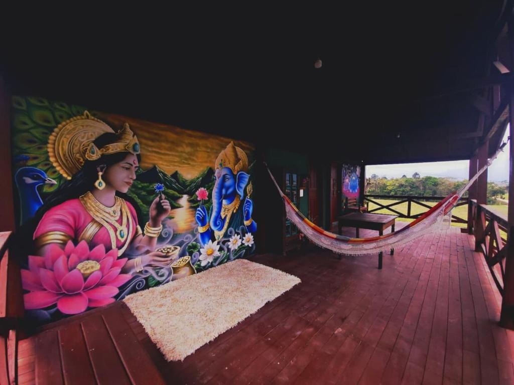 a mural of a woman sitting in a hammock at Casa da Sorte - campo, montanha, natureza e caminho da praia in Santo Amaro da Imperatriz