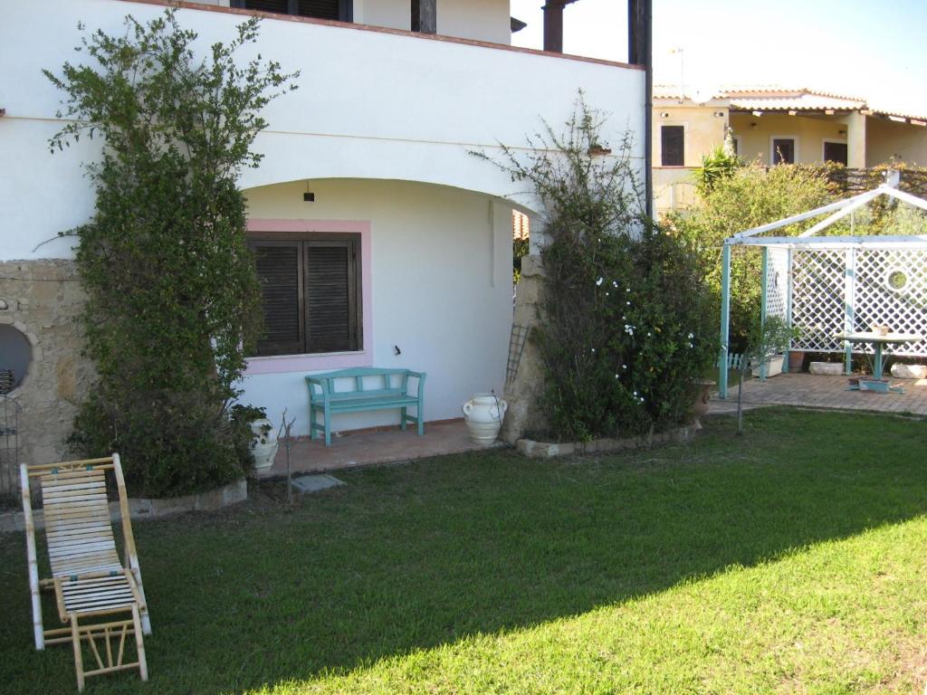 una casa con una panchina blu in un cortile di Le Tre Rose Mare a Capo Rizzuto