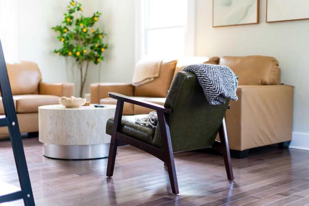 a living room with a chair and a couch at Jefferson & Grounds 3BR Steps from HWS and Hot Tub in Geneva