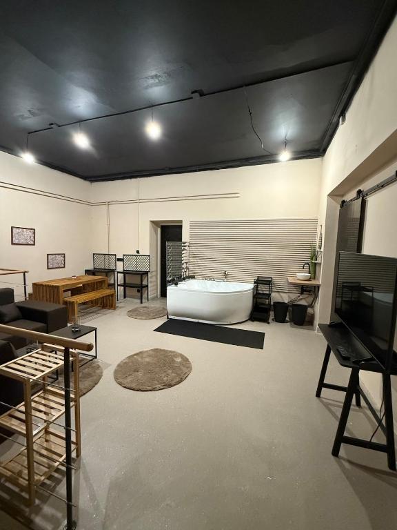 Cette grande chambre dispose d'une baignoire et d'une table. dans l'établissement Urban SPA Loft, à Golčŭv Jeníkov