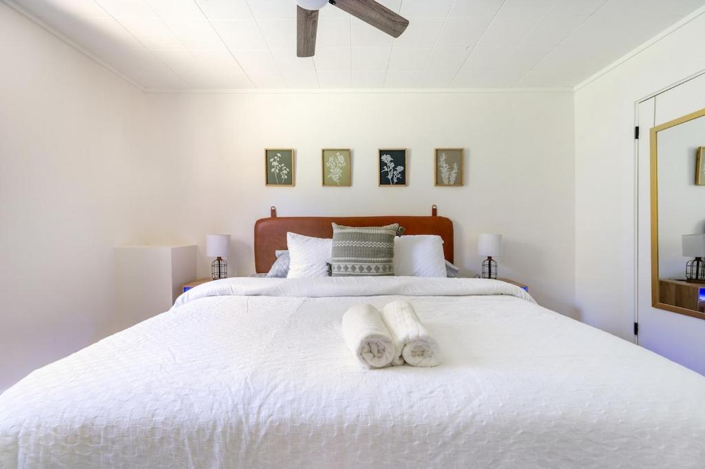 ein weißes Schlafzimmer mit einem weißen Bett und Handtüchern darauf in der Unterkunft Relax and Explore - Knoxville Stay with Hot Tub and Grill in Knoxville