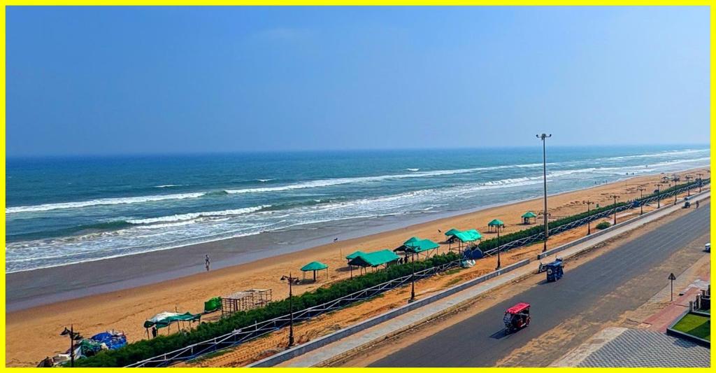 droga z plażą z parasolami i oceanem w obiekcie The Sea Beach Point Hotel Near Marine Drive Road-Jagannath Temple- Restaurant and Parking Facilities - Fully Air Conditioning Hotel w mieście Puri
