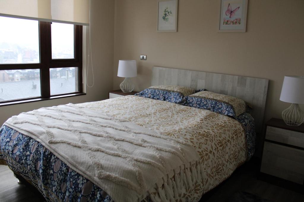 a bedroom with a large bed and a window at MPHB203 Departamento para 3 personas con Vista a Lago in Puerto Varas