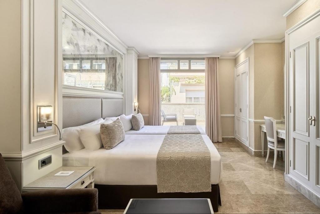 a bedroom with a large bed and a window at VP Jardín de Recoletos in Madrid