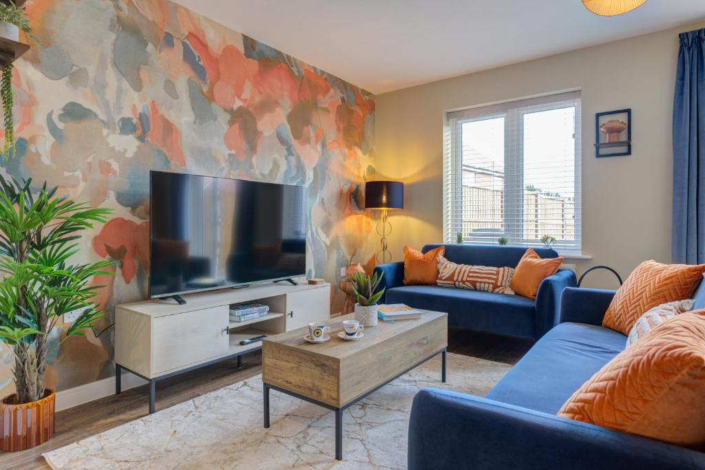a living room with a tv and a blue couch at Marriott House in Bourne
