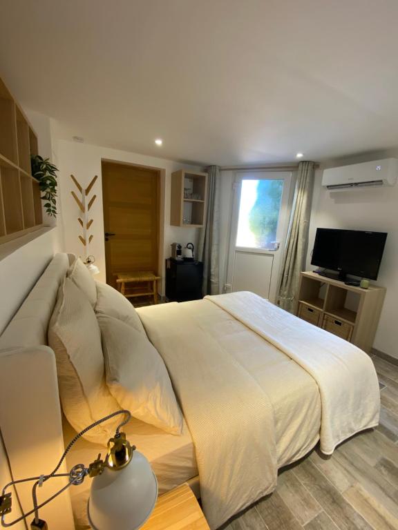 sypialnia z dużym białym łóżkiem i telewizorem w obiekcie Chambre entrée indépendante w mieście La Seyne-sur-Mer