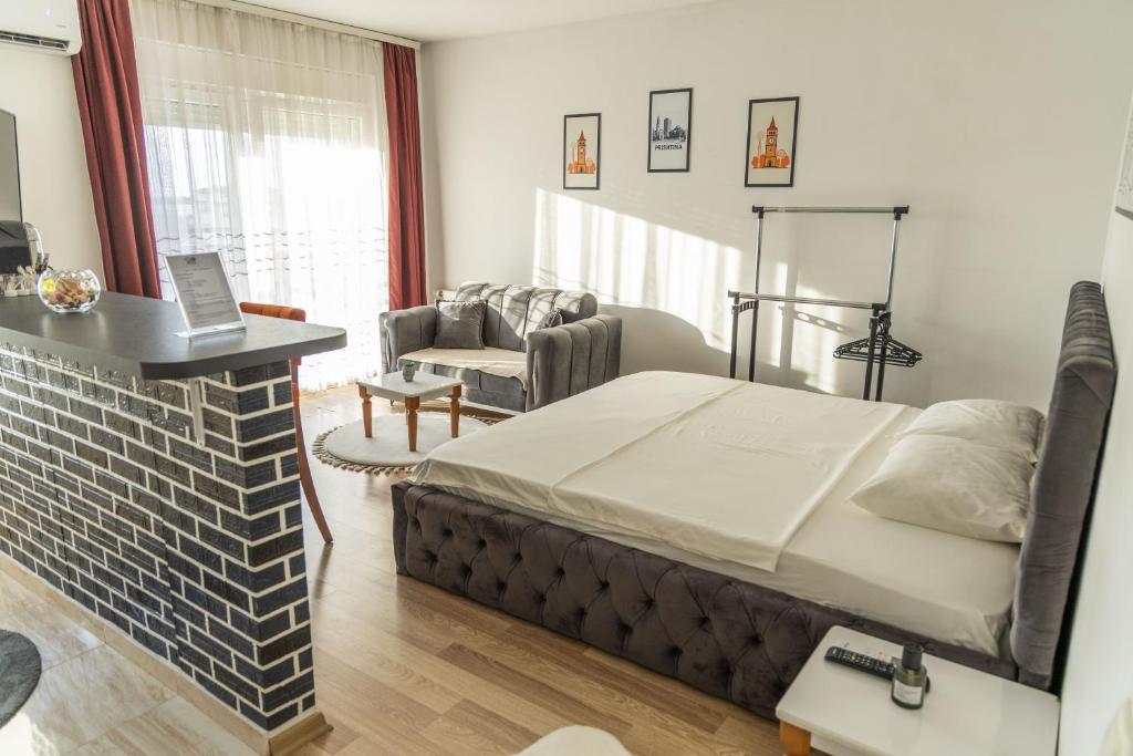 a bedroom with a bed and a living room at Infinit Apartment in Prishtinë