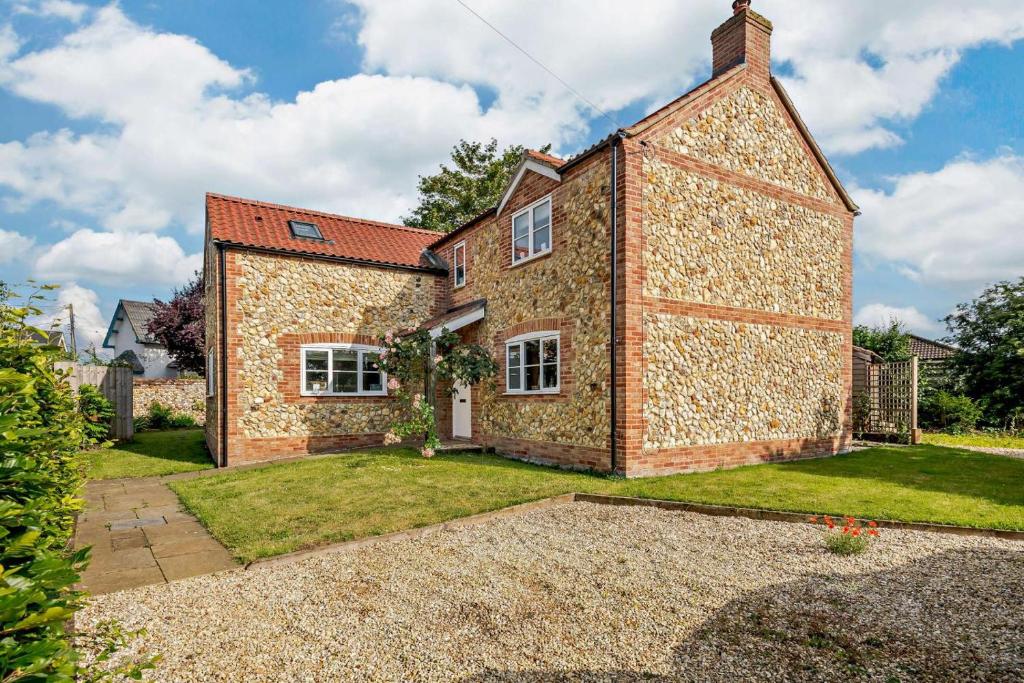 an exterior view of a brick house at Alcocks Cottage in Syderstone